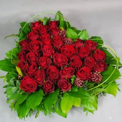 Heart of red roses with greens